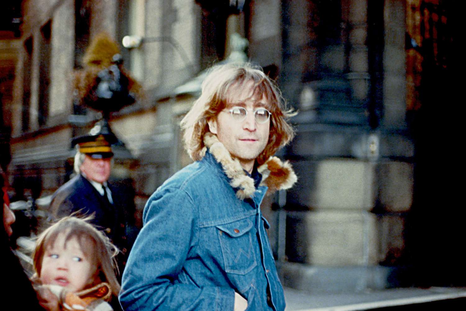 John Lennon posant pour une photo avec son fils en arrière-plan