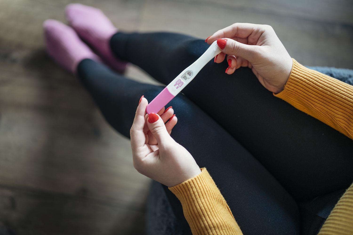 femme tenant un test de grossesse positif