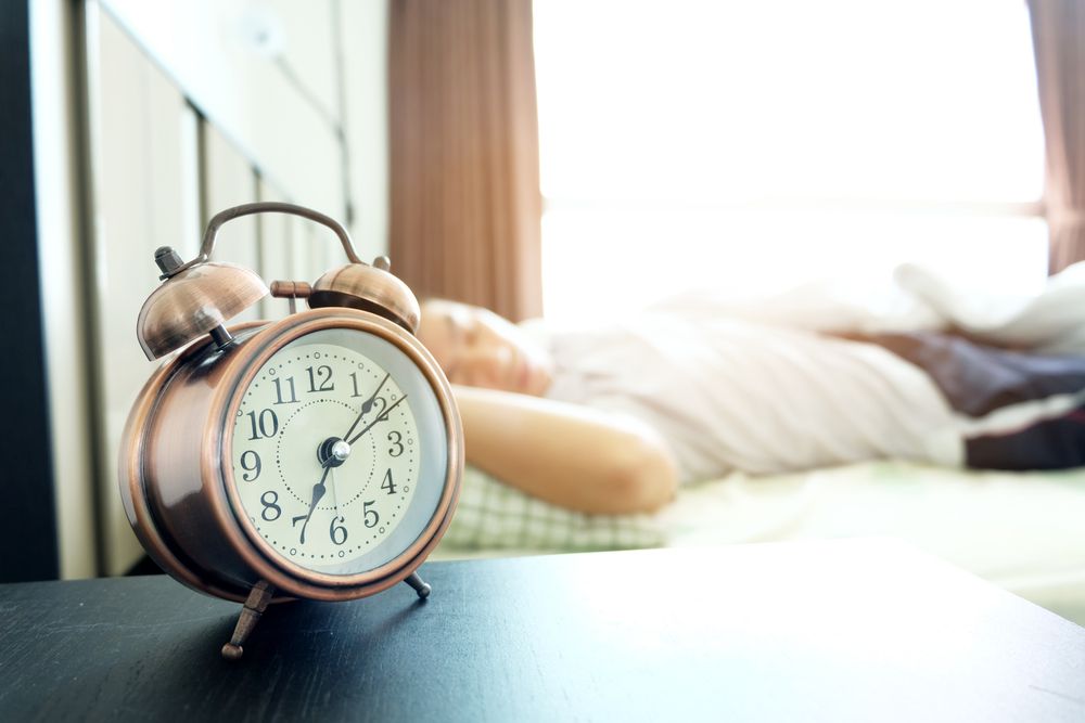 Femme au lit avec un réveil