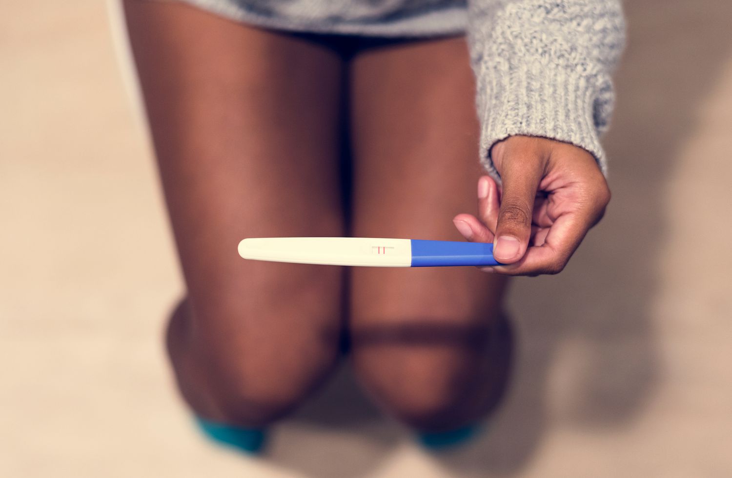 femme avec un test de grossesse positif